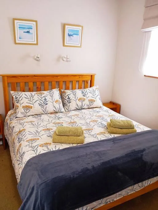 Bright bedroom with wooden bed frame and floral patterned bedding