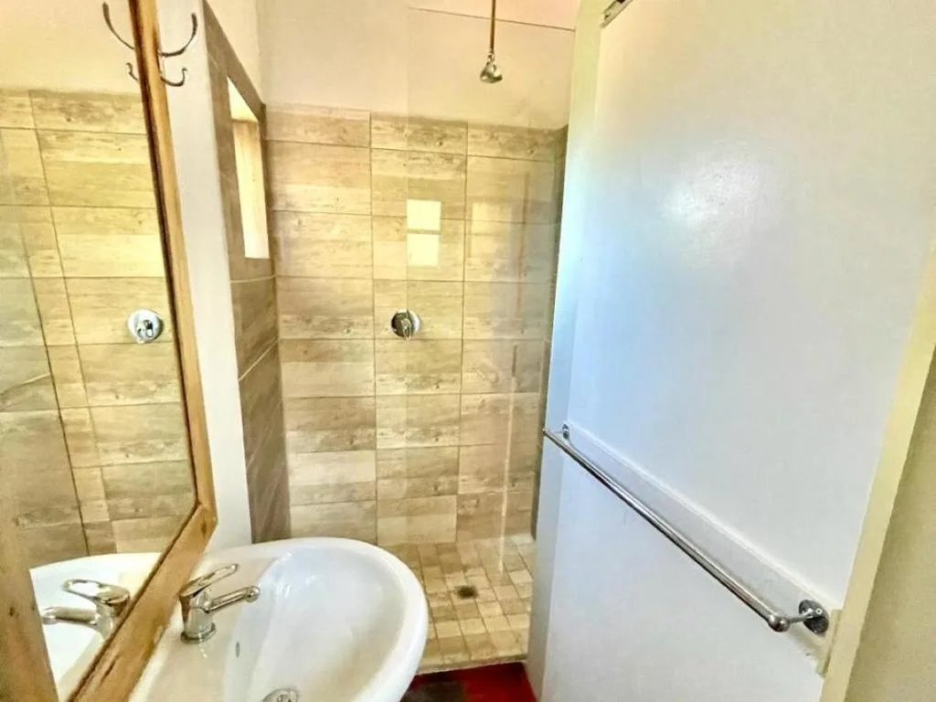 Modern bathroom with walk-in shower, vanity sink, and tiled walls