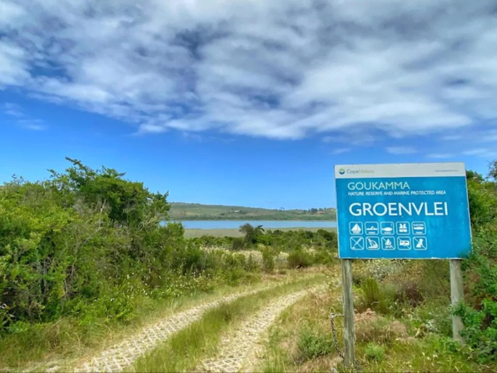 Scenic lagoon view with fynbos vegetation and Goukamma Nature Reserve sign