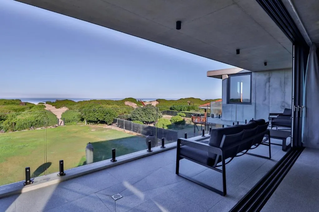 Modern deck with seating overlooking garden and ocean view beyond