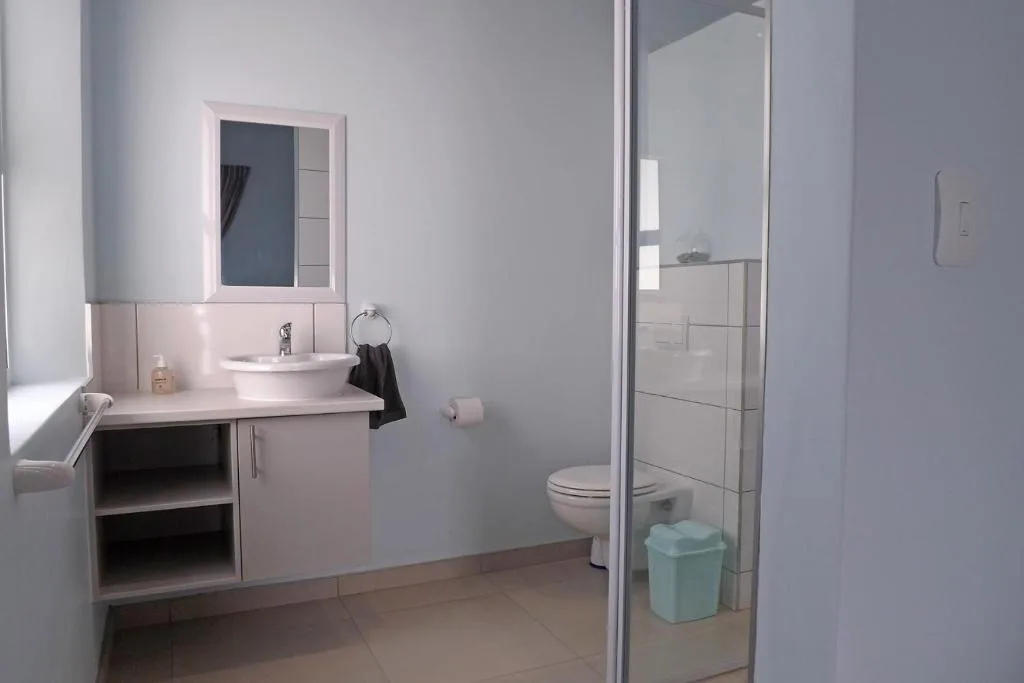 Modern bathroom with vanity sink, mirror, toilet, and shower enclosure