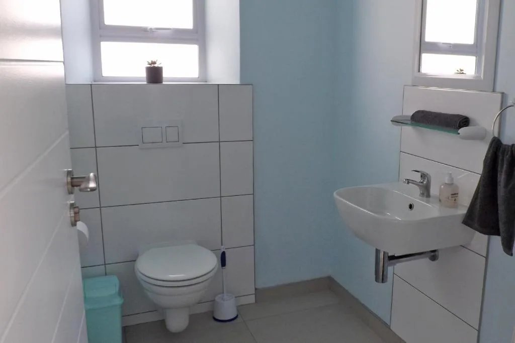 Clean bathroom with toilet, sink, and tiled shower enclosure