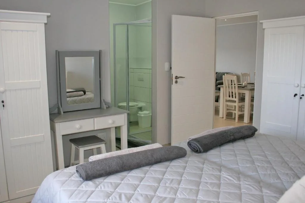Spacious bedroom with en-suite bathroom and vanity mirror setup