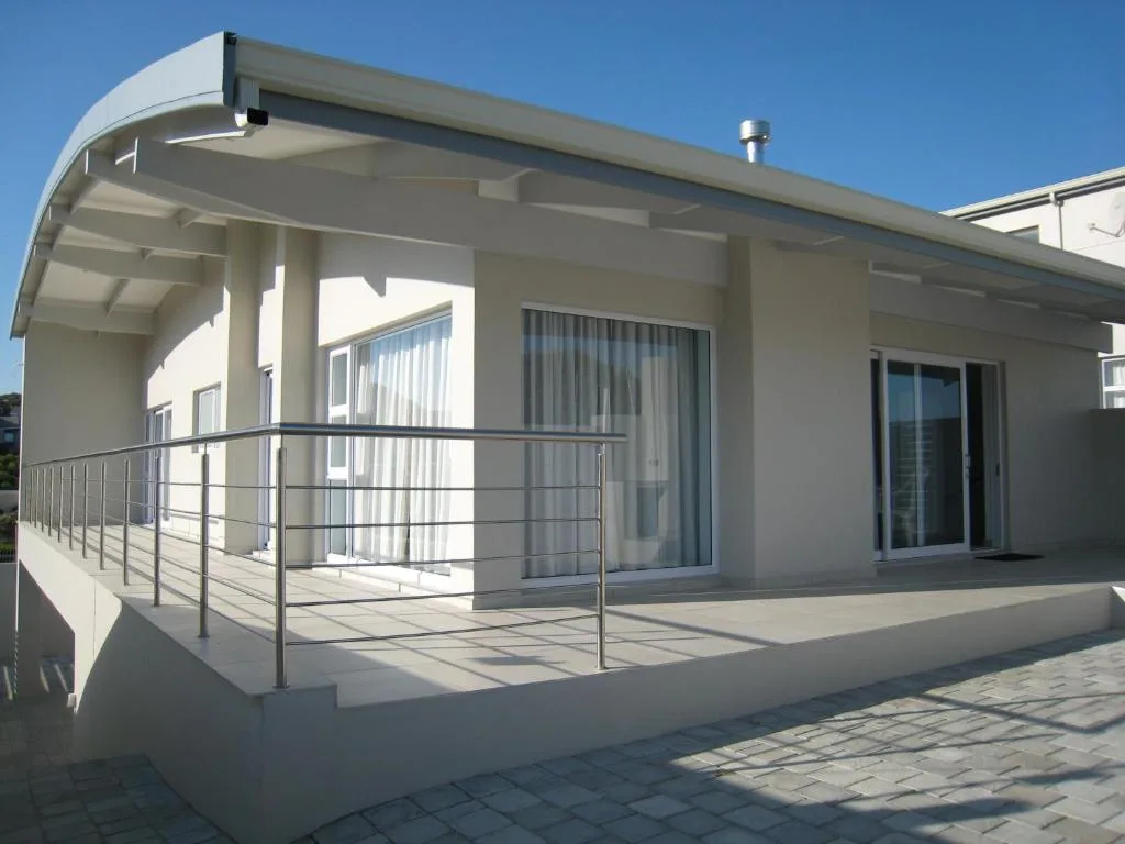 Modern covered patio with metal railing and sliding glass doors