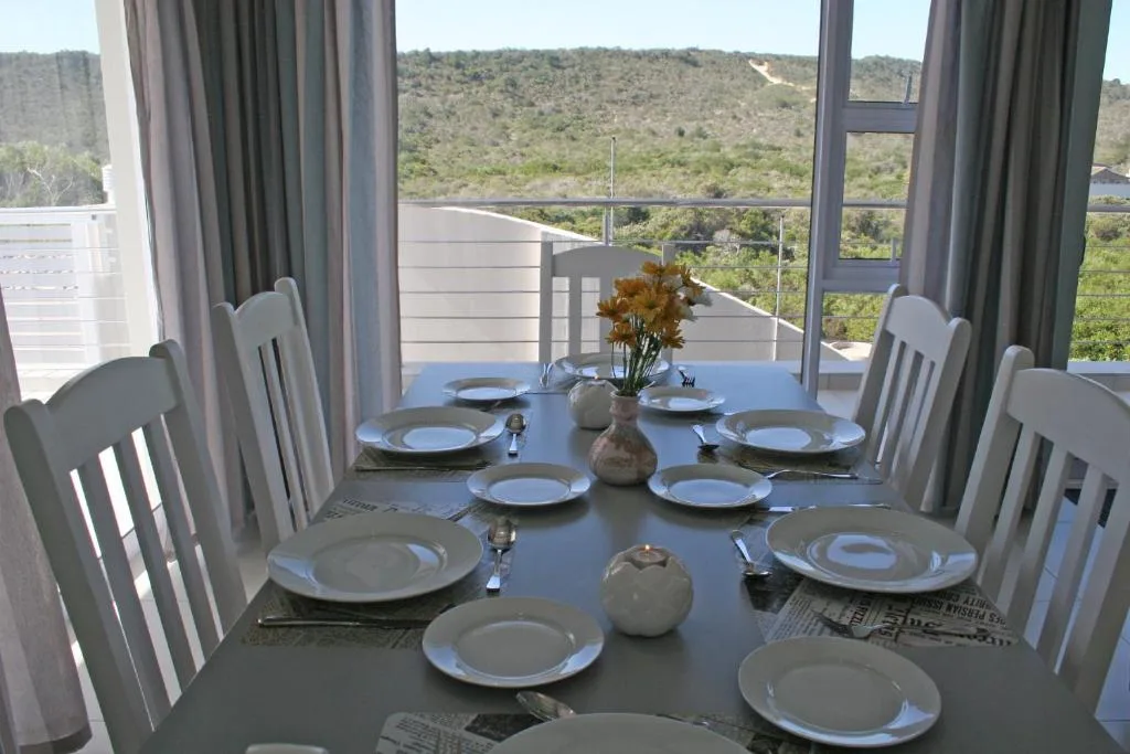 Dining table set for six with mountain view through large windows