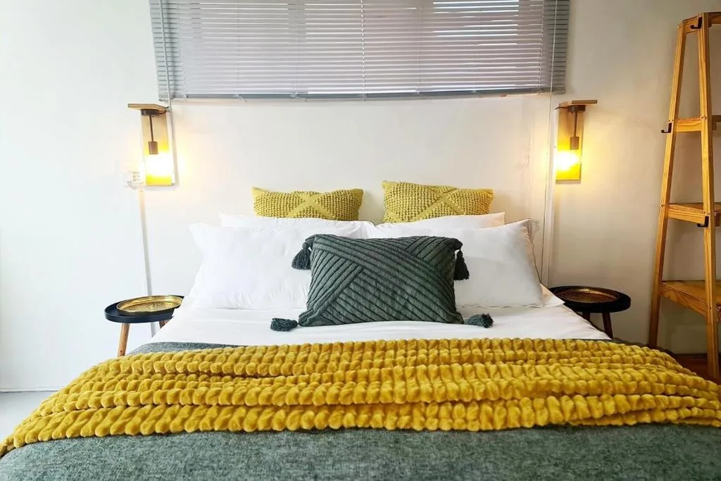 Modern bedroom with yellow quilted bedding and pendant lighting fixtures