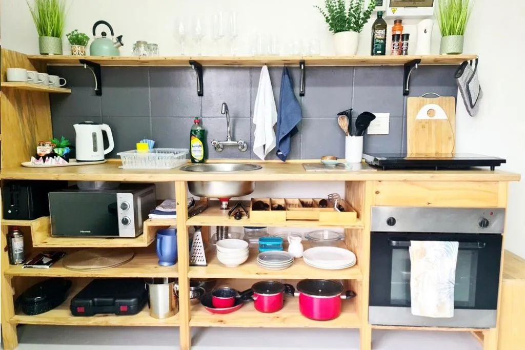 Wooden kitchen with stove, open shelving, and organized cooking utensils