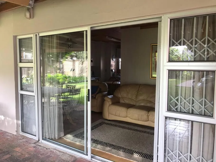 Sliding glass doors opening onto patio with garden views and seating