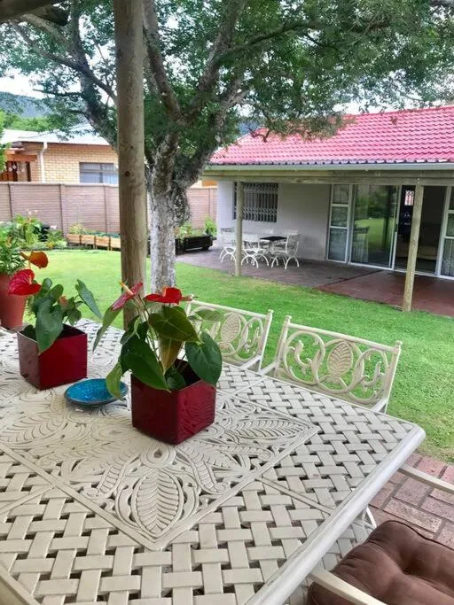 Outdoor patio with decorative tiles, potted flowers, and garden views