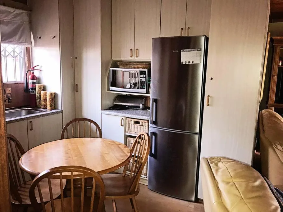 Kitchen with stainless steel refrigerator, microwave, and dining table with chairs