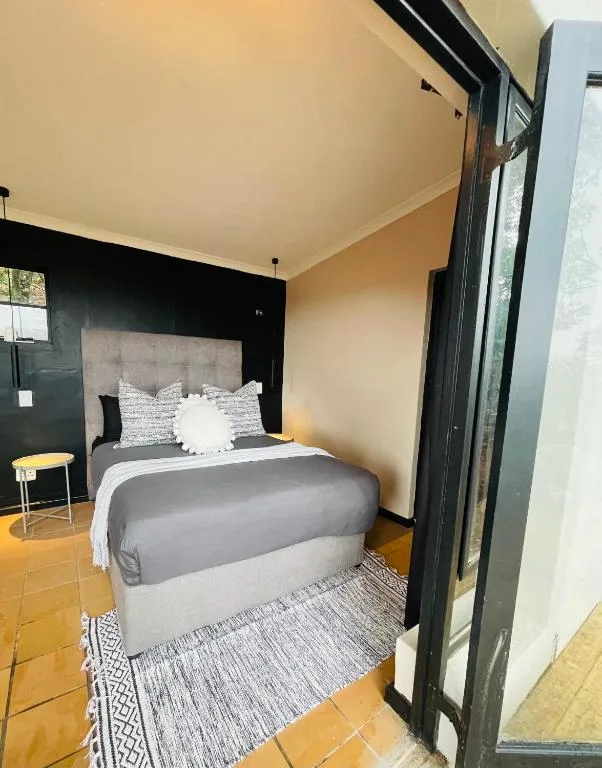 Modern bedroom with gray upholstered bed and black accent wall