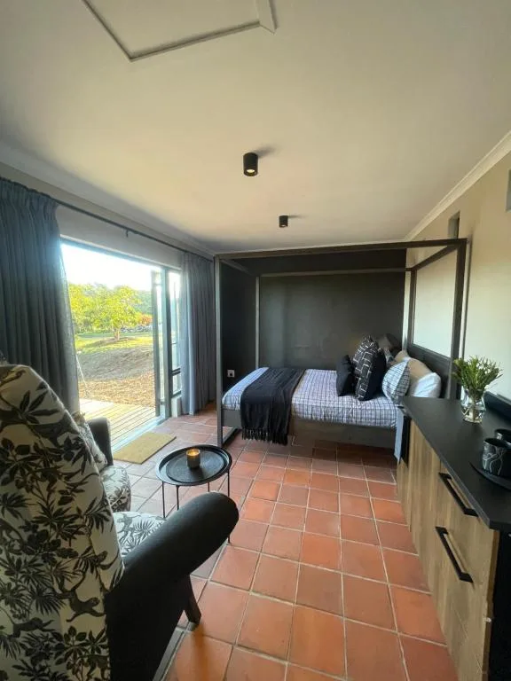 Modern bedroom with four-poster bed and glass doors opening to deck
