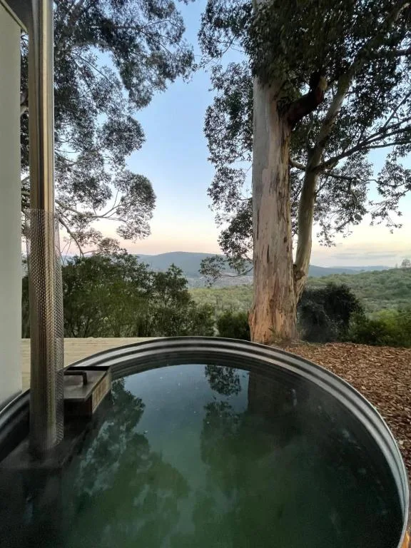 Outdoor hot tub with mountain views and tall eucalyptus trees