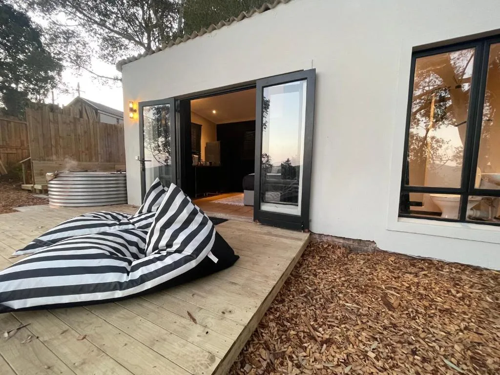 Modern outdoor deck with striped lounger and open glass doors