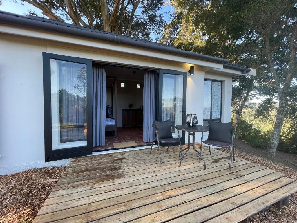 Wooden deck with seating area overlooking garden grounds
