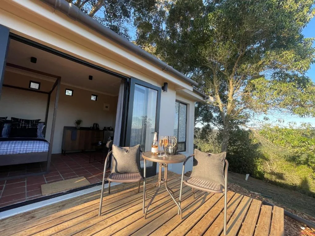 Wooden deck with seating overlooking gardens and natural landscape