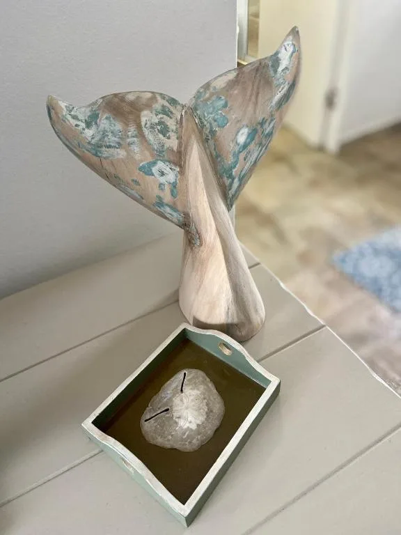 Decorative whale tail sculpture with coastal-themed artwork on display