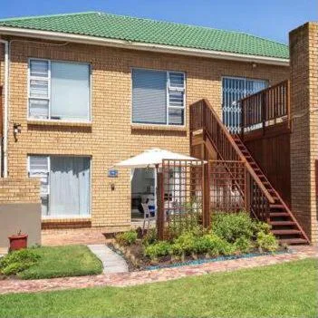 Brick vacation apartment with green roof and wooden deck stairs
