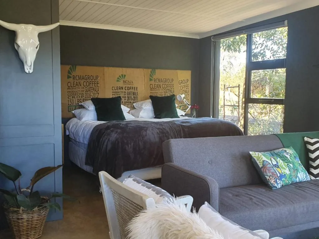Studio bedroom with queen bed, coffee sack headboard, and lounge seating area