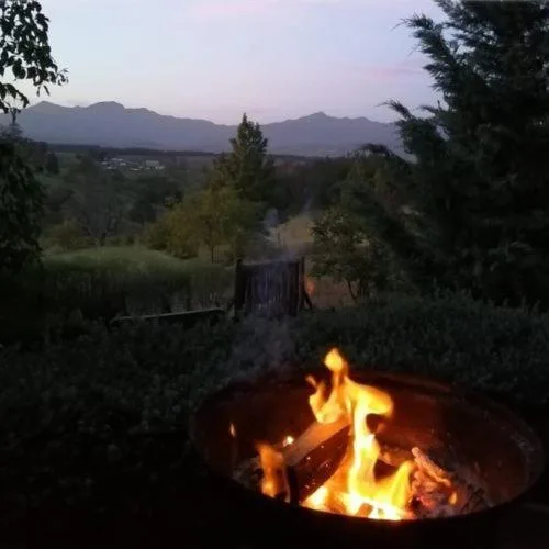 Fire pit with mountain and river valley views at dusk