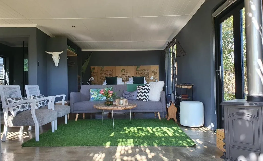 Modern lounge with gray sofa, white chairs, and lush green artificial turf flooring