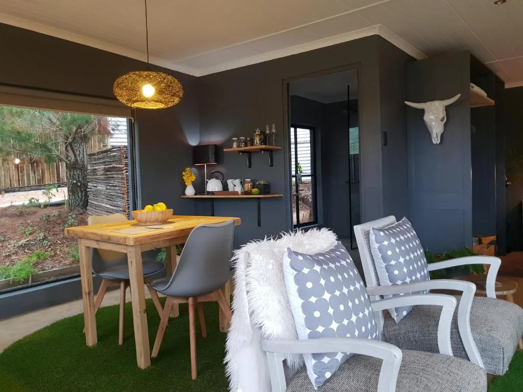 Modern lounge with dining table, patterned cushions, and garden views