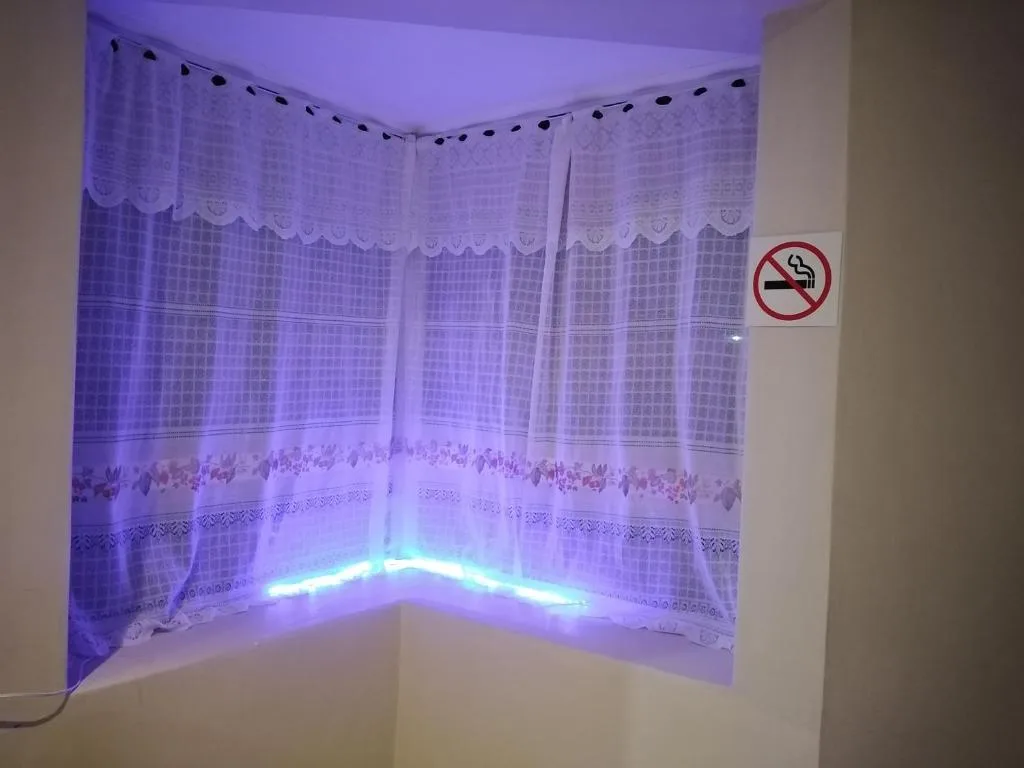 Corner window with lace curtains and blue neon accent lighting