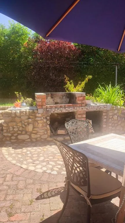 Outdoor patio with built-in stone braai and dining seating area
