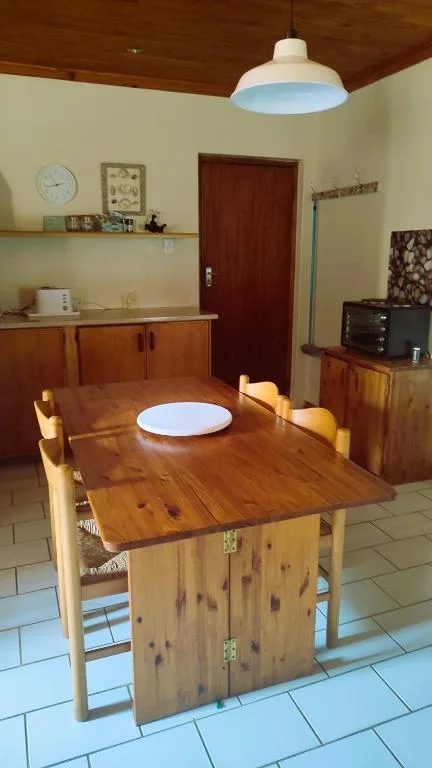 Wooden dining table with chairs in warm, naturally lit room