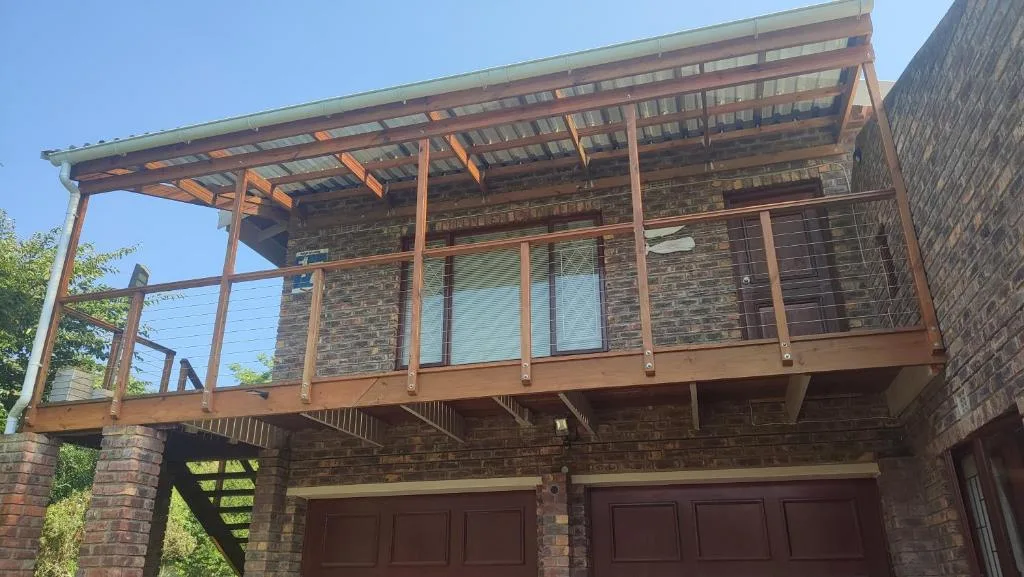 Modern brick home with wooden deck and pergola overhead structure