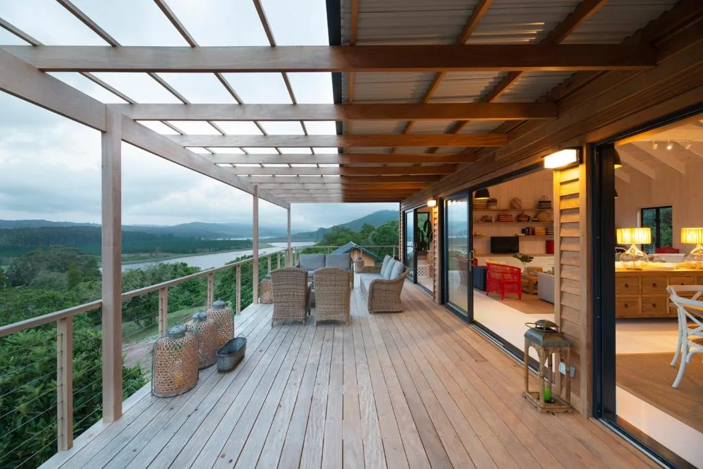 Expansive wooden deck with lounge chairs overlooking lagoon and mountain views