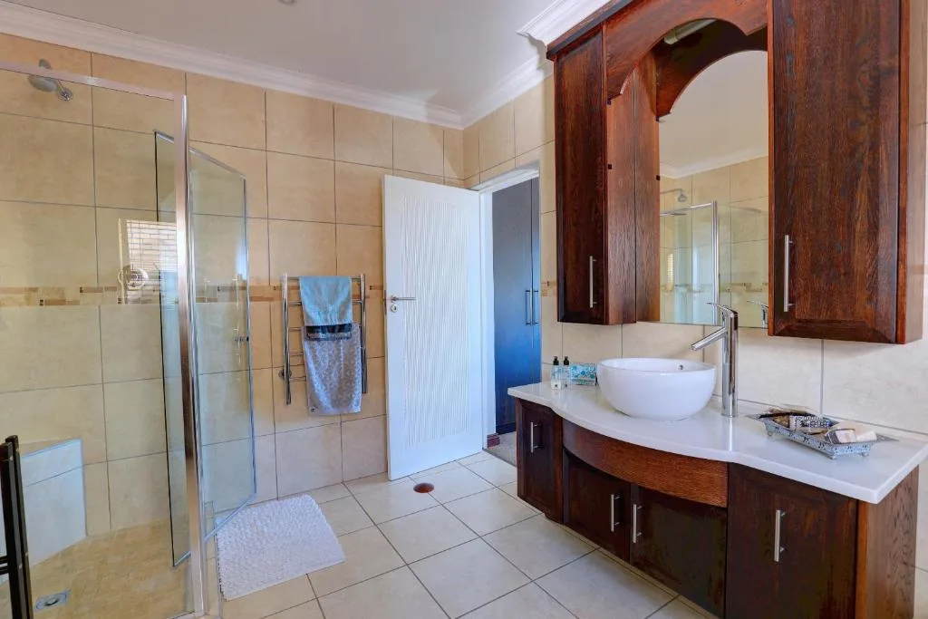 Modern bathroom with walk-in shower, vessel sink, wooden vanity cabinet