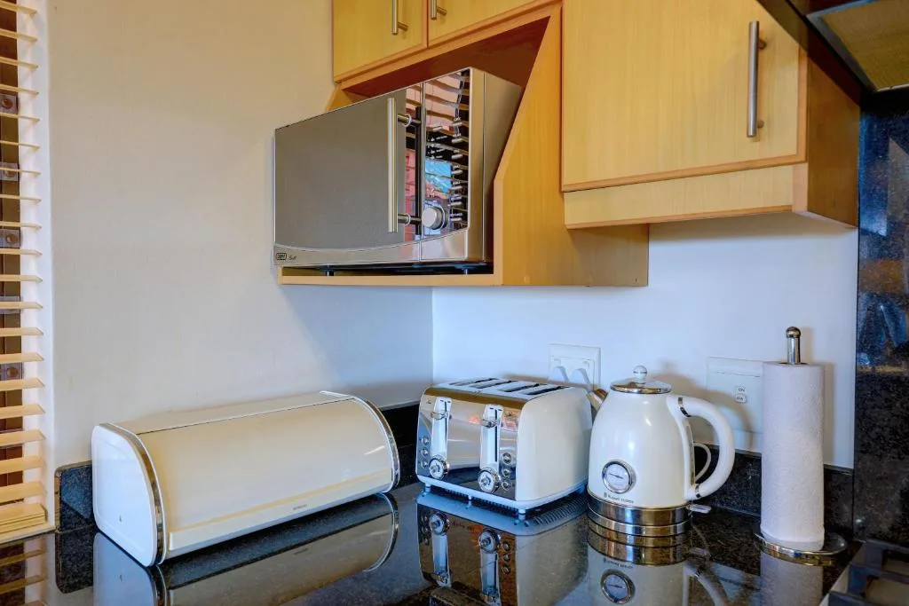 Kitchen counter with microwave, kettle, toaster, and bread bin
