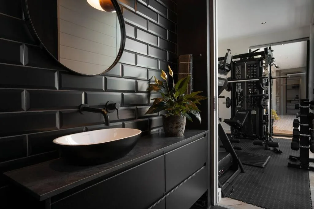 Modern black bathroom with elegant vessel sink and round mirror