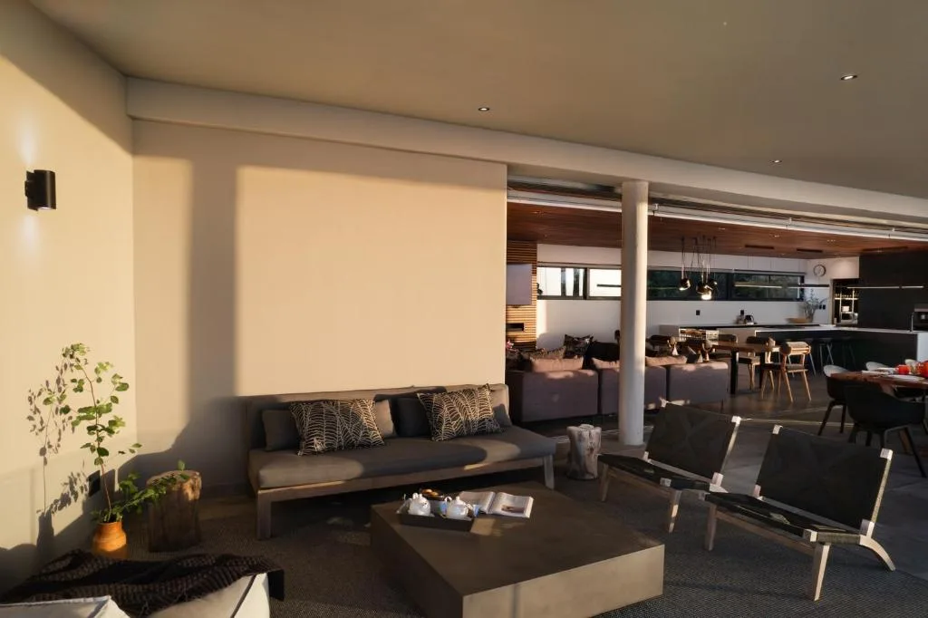 Modern lounge with gray sofa, black coffee table, and open-plan kitchen beyond