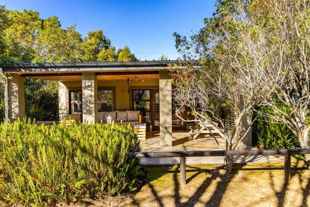 Modern garden cottage with covered porch, wooden deck, and native landscaping