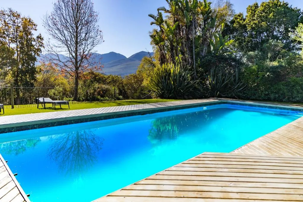 Sparkling turquoise swimming pool with mountain views and manicured gardens