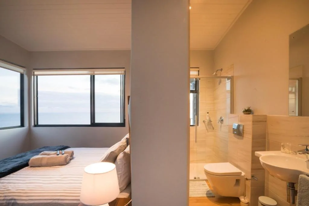 Bedroom with ocean view windows and ensuite bathroom access