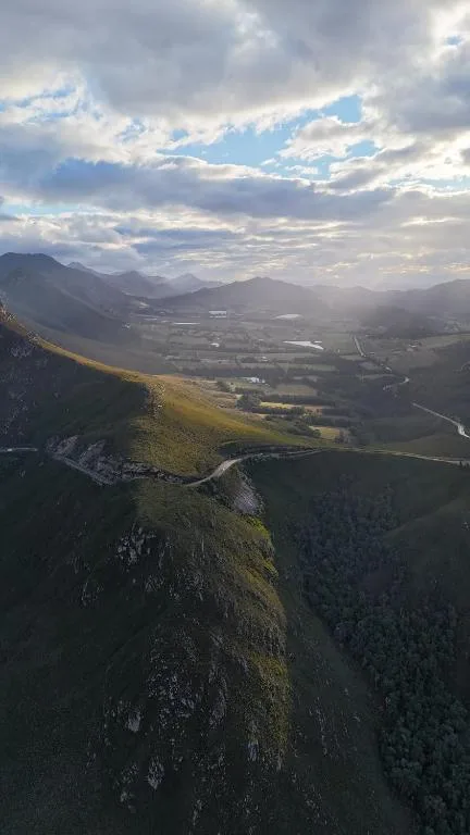 Scenic mountain valley landscape with winding river and dramatic clouds