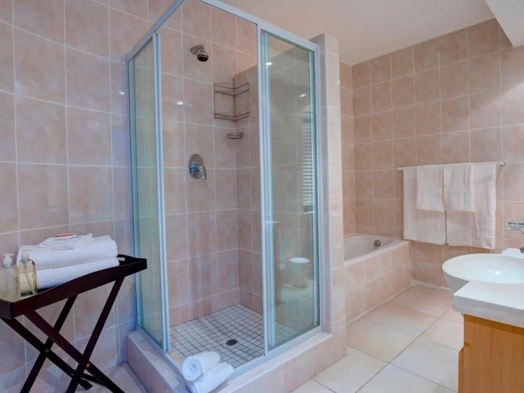 Modern bathroom with walk-in shower, bathtub, and dual vanities