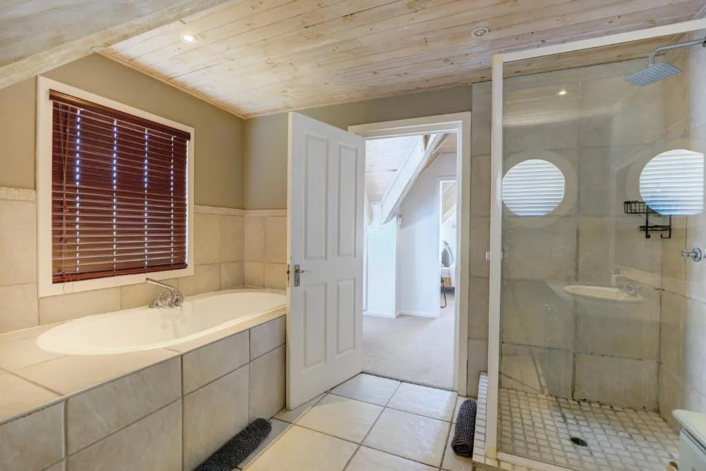 Spacious bathroom with bathtub, shower enclosure, and wooden ceiling