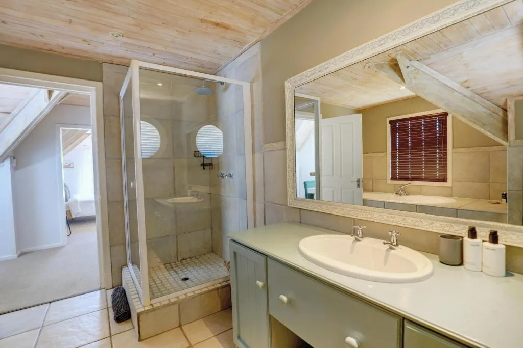Spacious bathroom with walk-in shower, double vanity sink, and large mirror