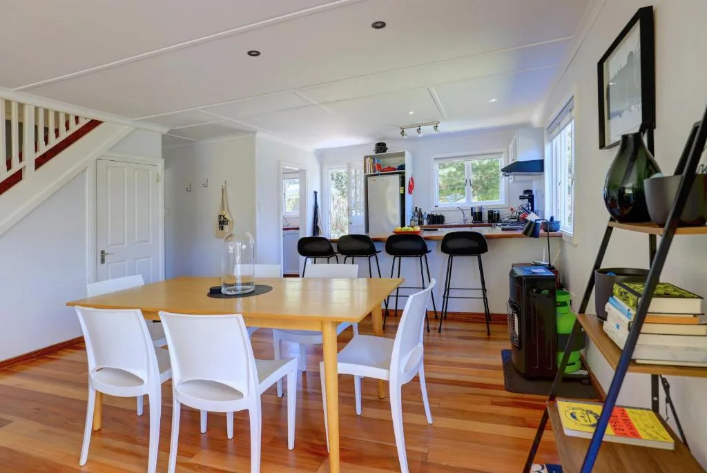 Open-plan dining area with wooden table and white chairs