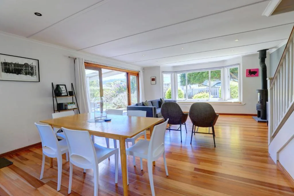 Open-plan dining and lounge area with wooden table and garden views