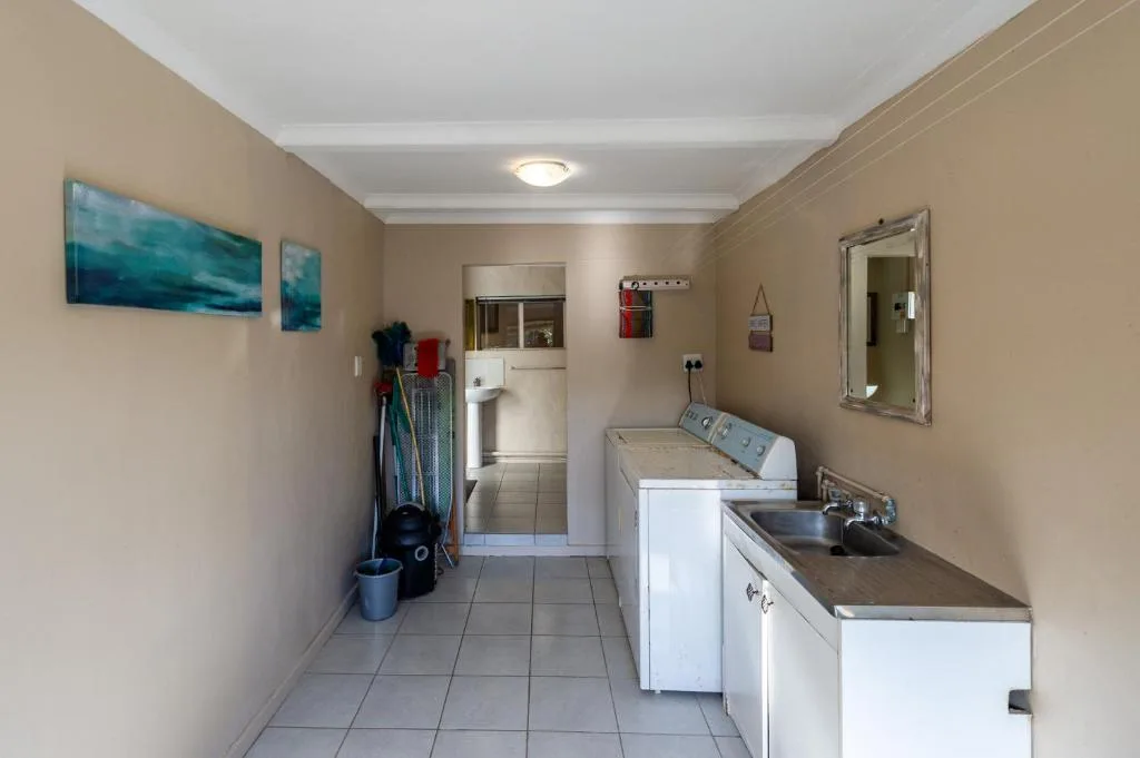 Laundry room with washer, dryer, sink, and wall decor