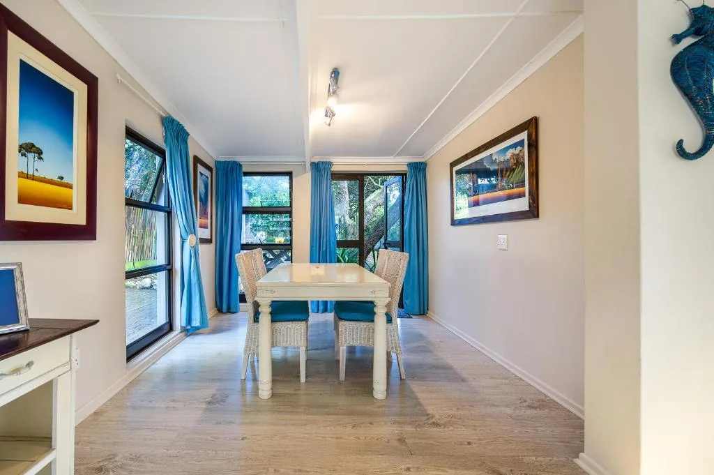 Bright dining room with cream table, wicker chairs, blue curtains