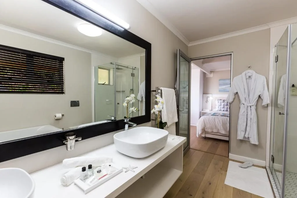 Modern bathroom with vessel sink, large mirror, and walk-in shower enclosure