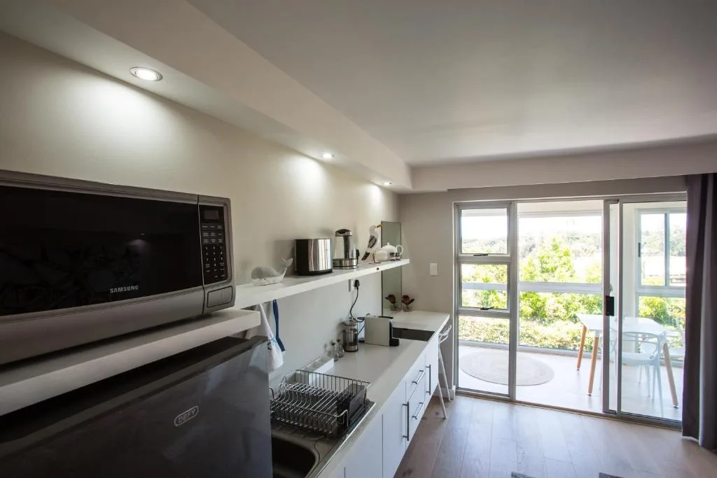 Modern kitchen with stainless steel appliances and deck access doors