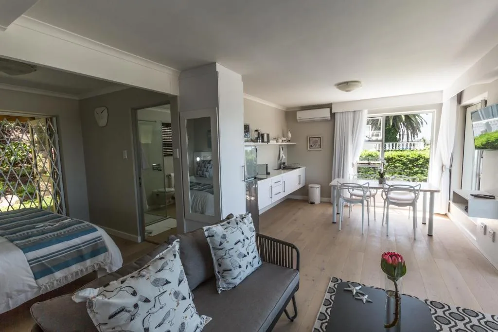 Open-plan lounge with seating, kitchen, and dining area visible