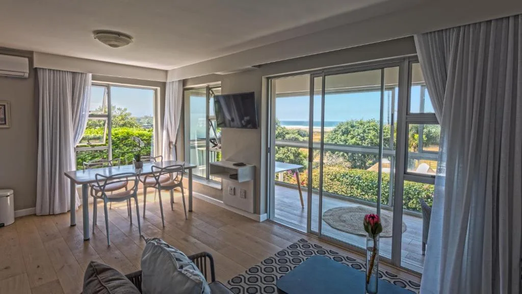 Open-plan lounge with ocean views through large sliding glass doors